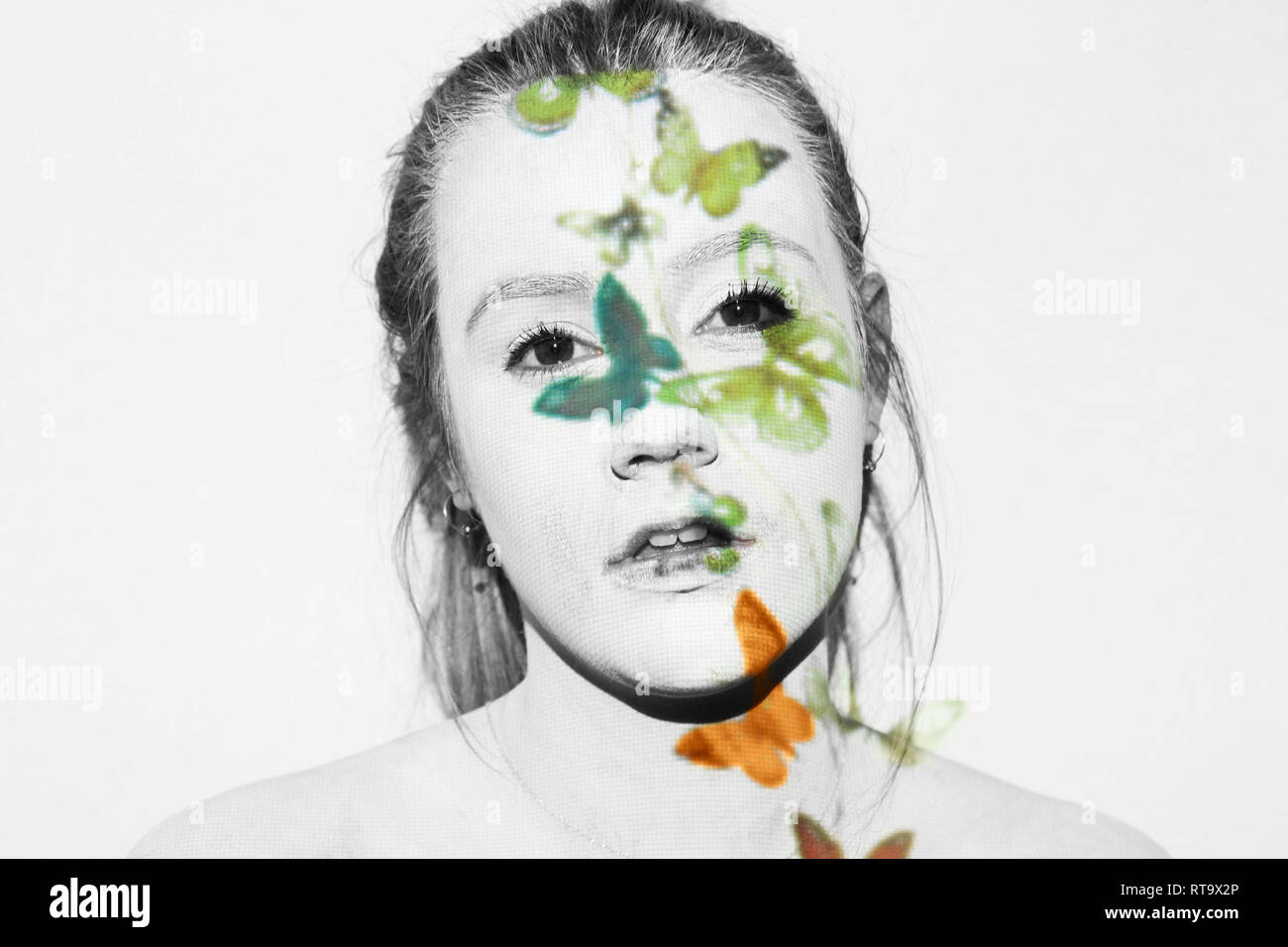 Woman covered in white paint has butterflies projected onto her. She ...