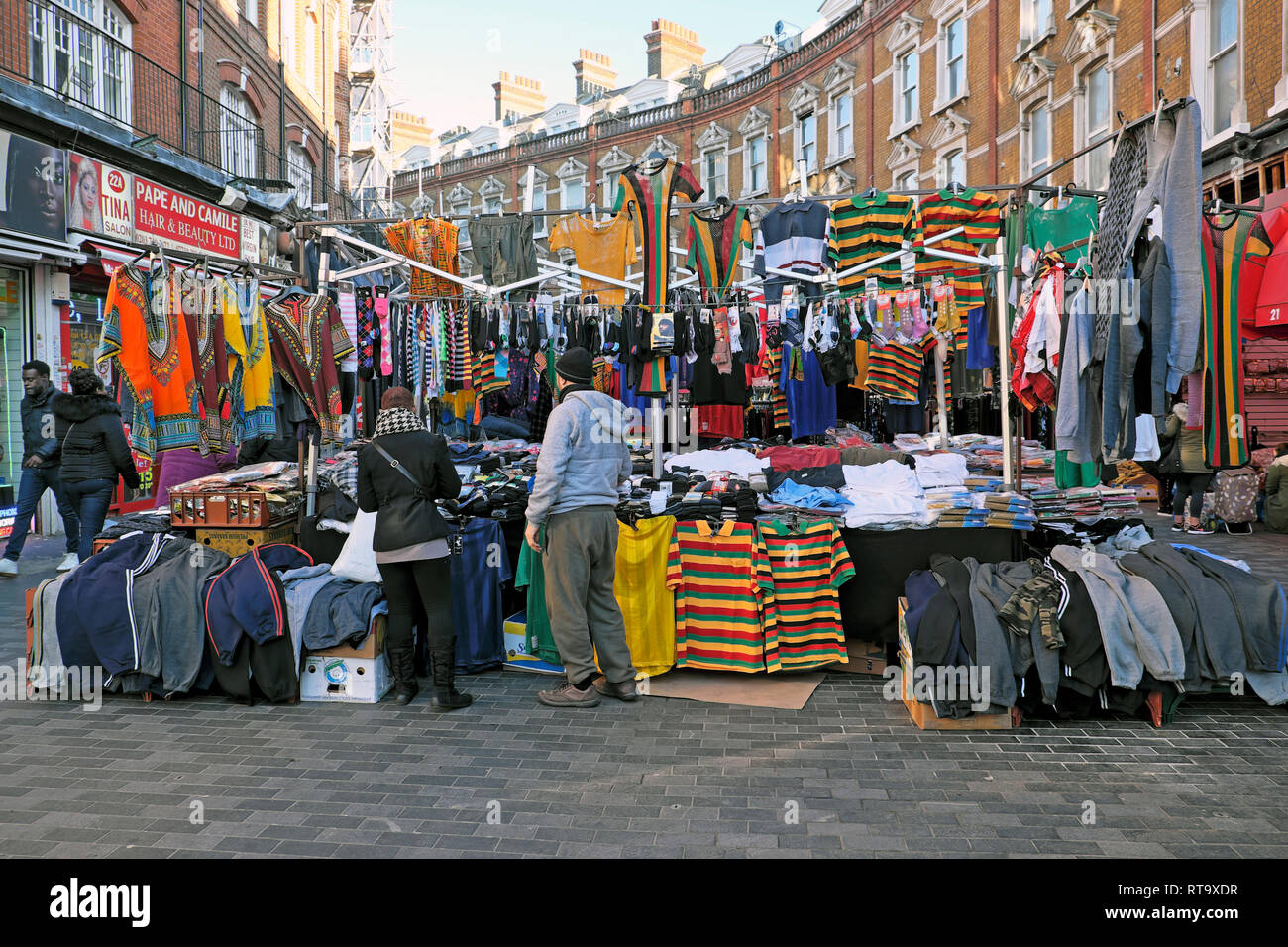 A market trader man selling mens clothing in Brixton street market scene Electric Avenue Brixton South London England UK   KATHY DEWITT Stock Photo