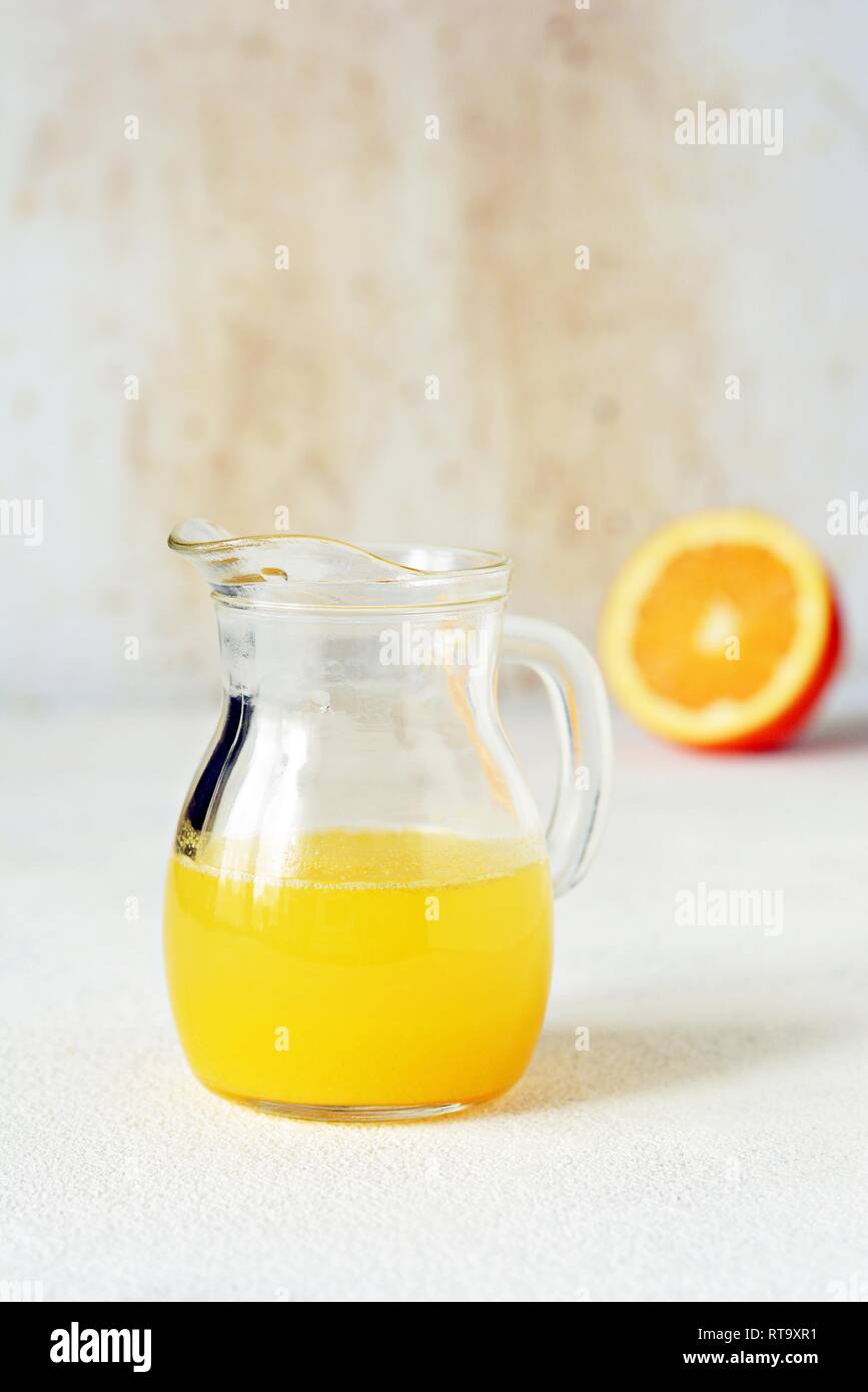 A carafe of orange juice for breakfast on a light background. Healthy