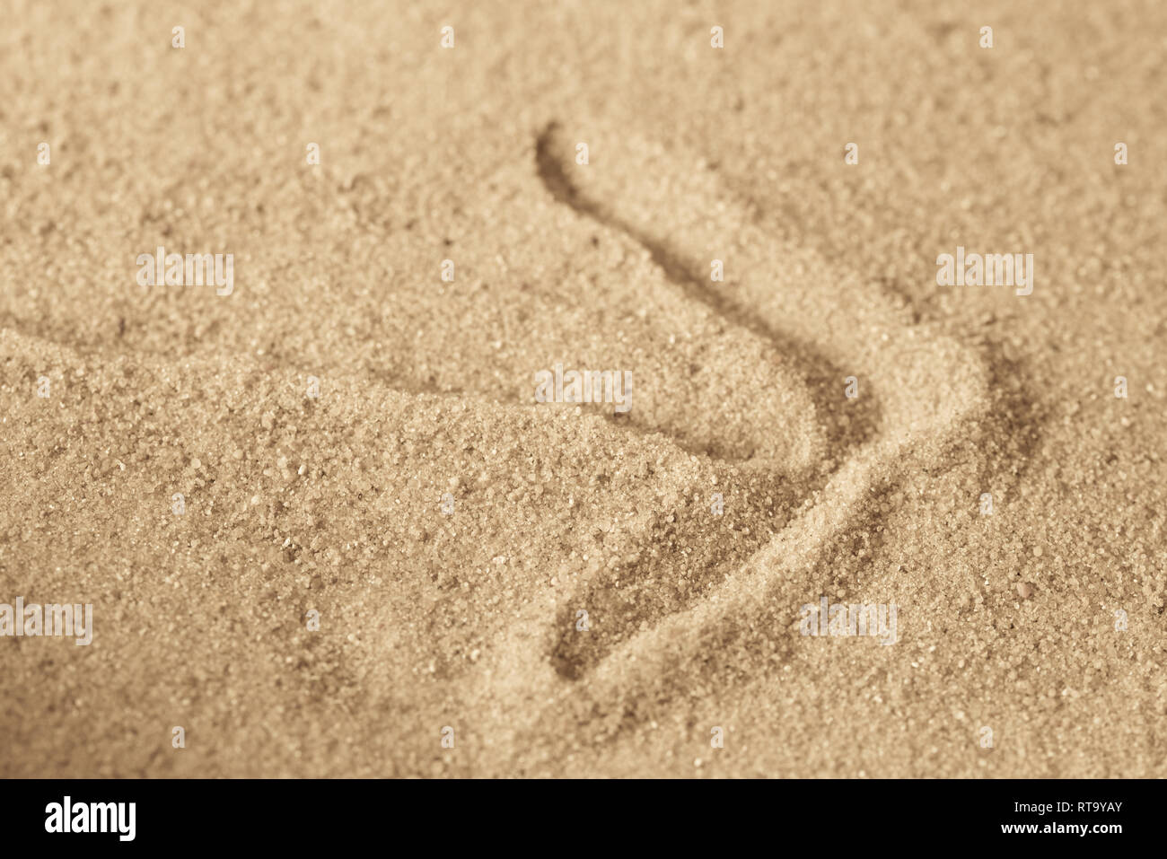 arrow sign on sandy background macro Stock Photo - Alamy