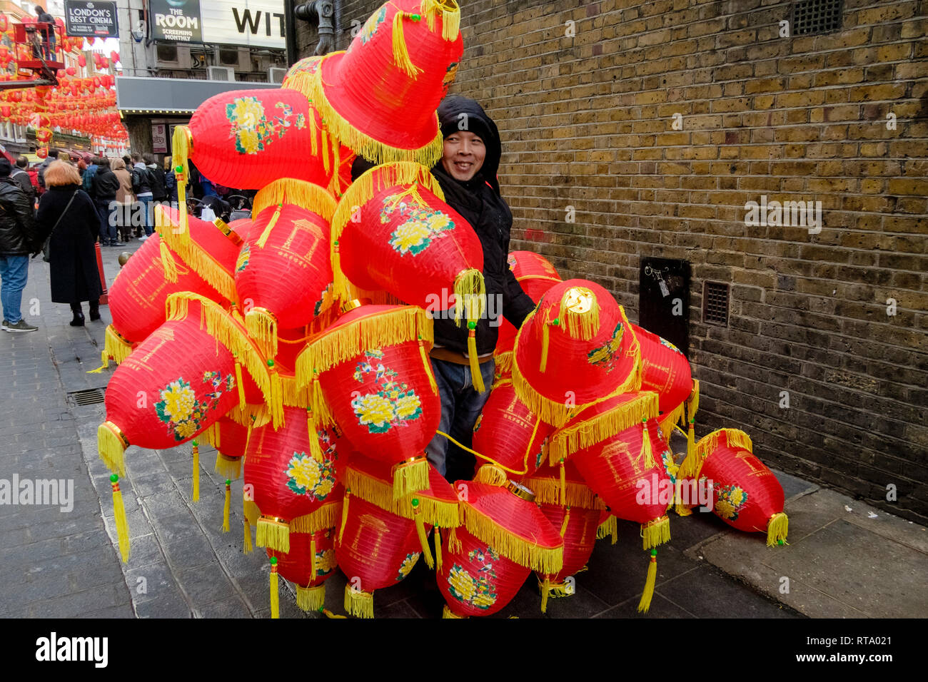 Man carrying Chinese lanterns during preparations for Chinese New Year, Lisle street, London, UK Stock Photo
