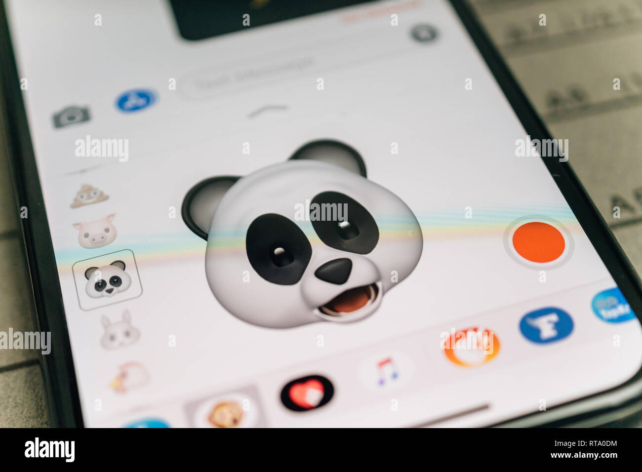 PARIS, FRANCE - NOV 9 2017: Panda bear 3d animoji emoji generated by Face ID facial recognition system with astonished face emotion close-up of the new iphone X 10 Display - tilt-shift lens used  Stock Photo