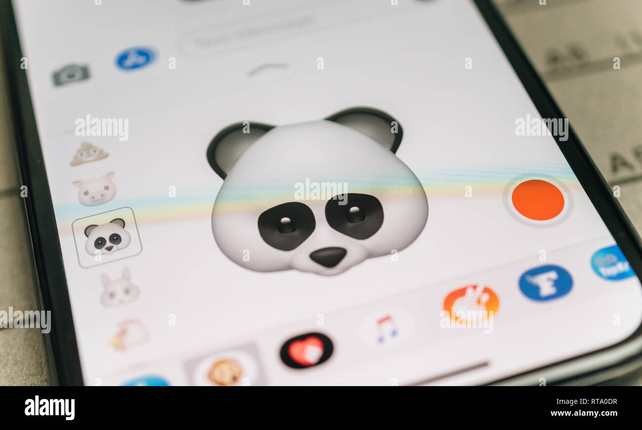 PARIS, FRANCE - NOV 9 2017: Panda bear 3d animoji emoji generated by Face ID facial recognition system with sad face emotion close-up of the new iphone X 10 Display - tilt-shift lens used  Stock Photo
