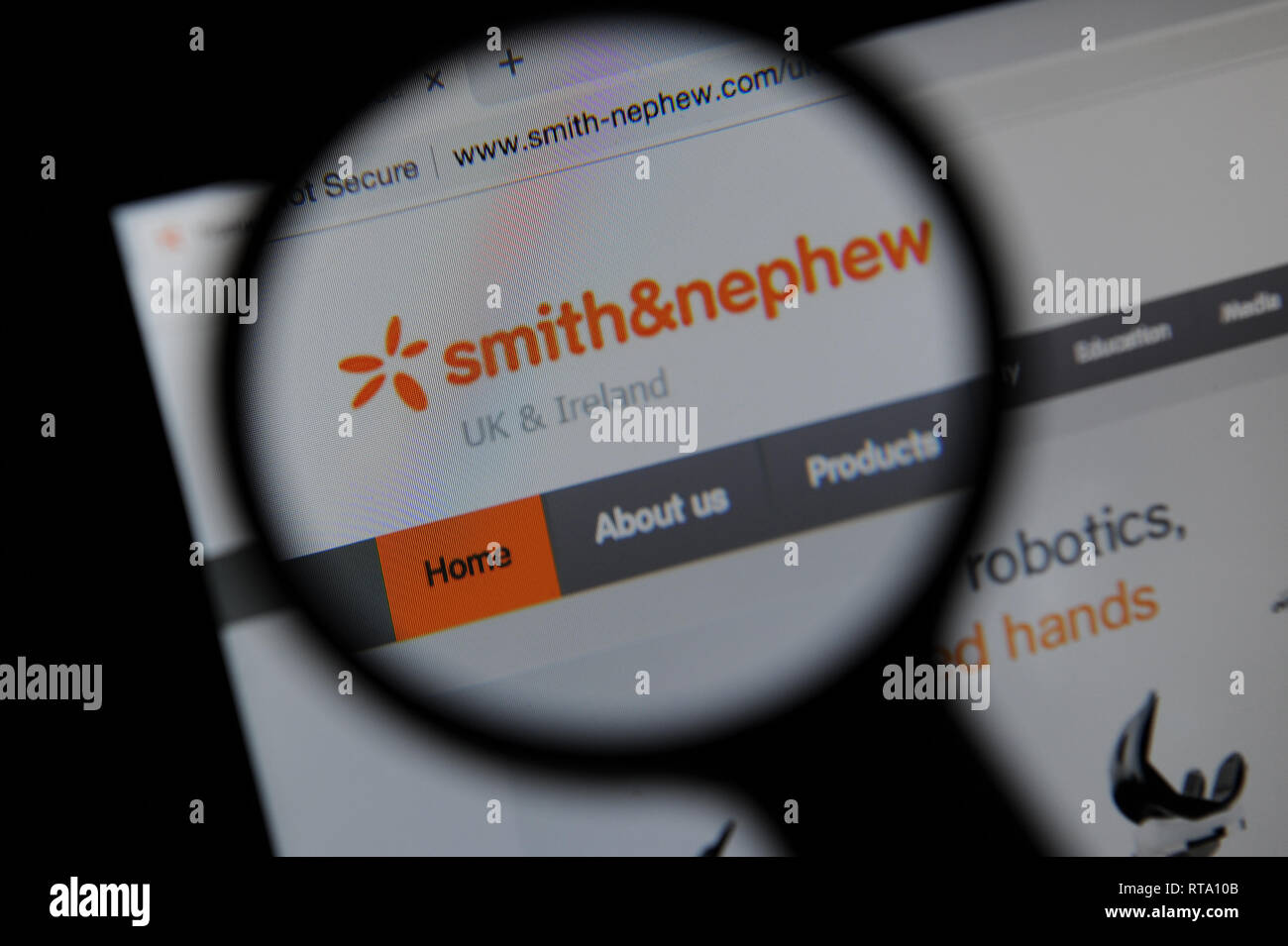 The Smith & Nephew website seen through a magnifying glass Stock Photo