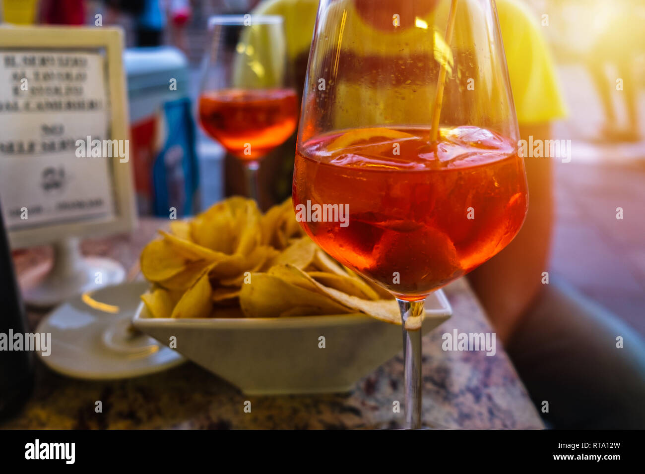 Venitian Spritz in a cafe on the embankment of the Grand Canal.Blurred background and sun light.selective focus Stock Photo
