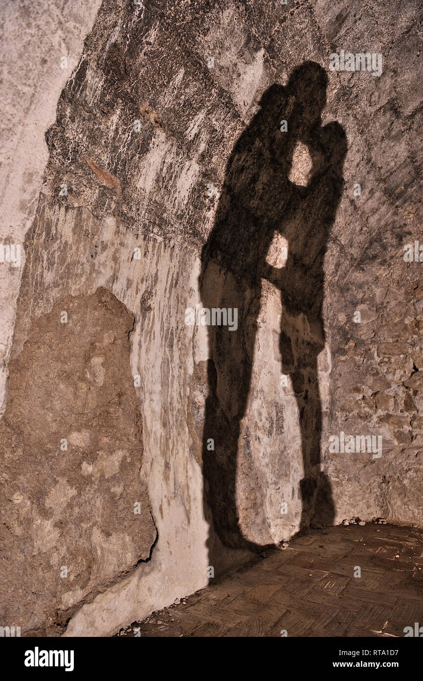 shadow on curved stone wall of a couple kissing Stock Photo