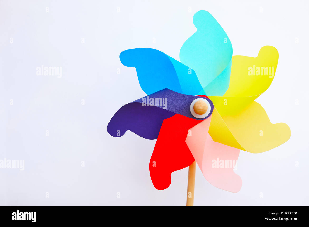 Pinwheeling Multicolored pinwheel windmill toy isolated on white. Summer and ...