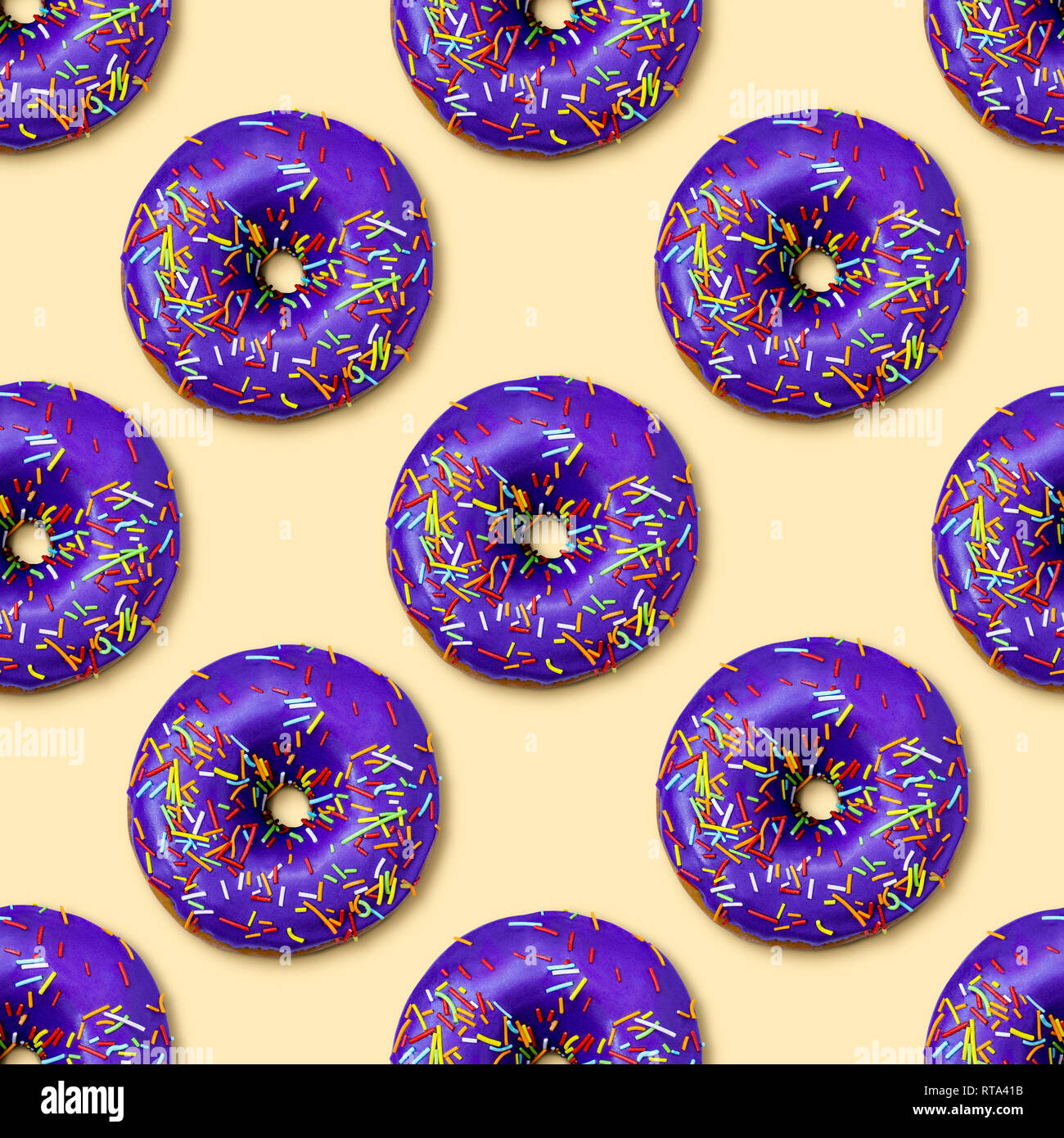 Bright flat seamless pattern with donuts. Violet glazed donuts with colorful sugar sprinkles on yellow background. Fashion minimalism style. Top view Stock Photo