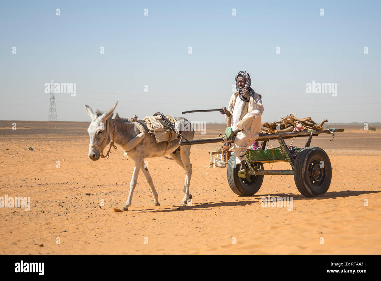 Khartoum, Sudan, 18th December 2015: sudanese man traveling with his donkey in Numibian desert Stock Photo