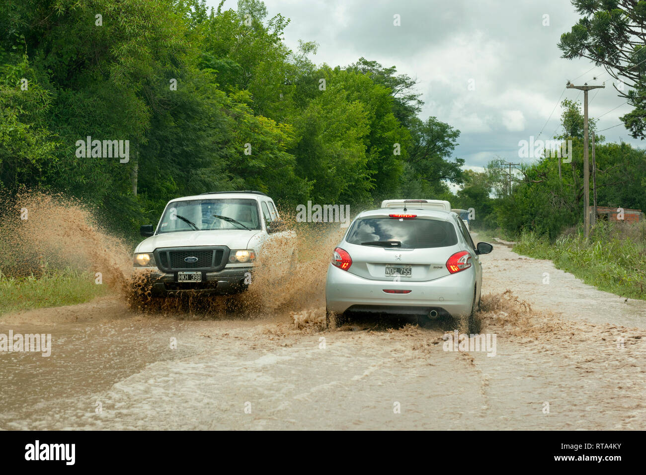 Traffic passing on a flooding affected road near El Carril, Salta Province, Argentina. Stock Photo
