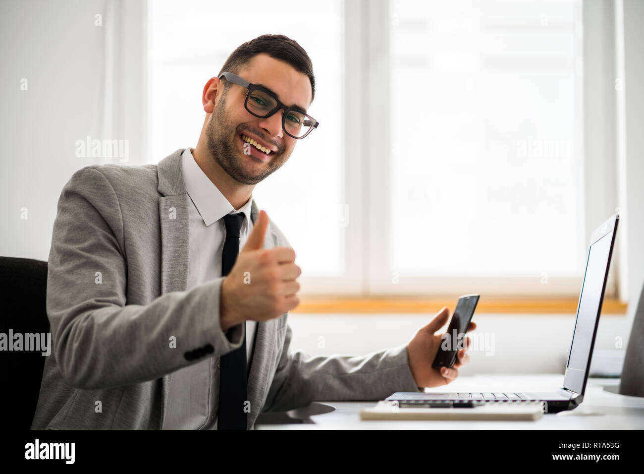 Young happy businessman is working in office. Stock Photo