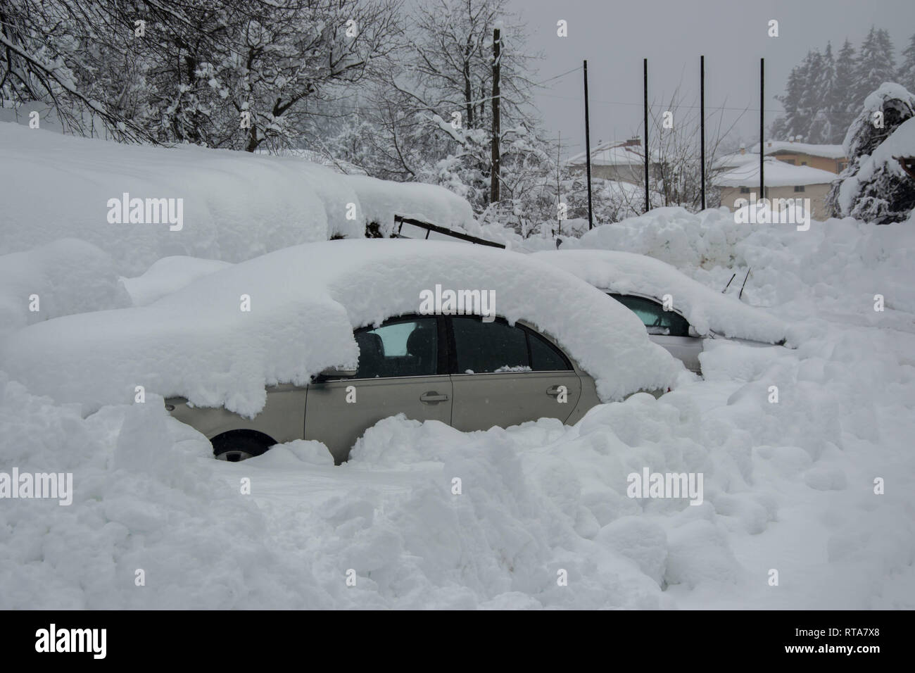 Snow covered cars in winter season, snowstorm Automobiles covered in snow, in blizard, winter season in Bulgaria, Snow covered cars in winter season Stock Photo