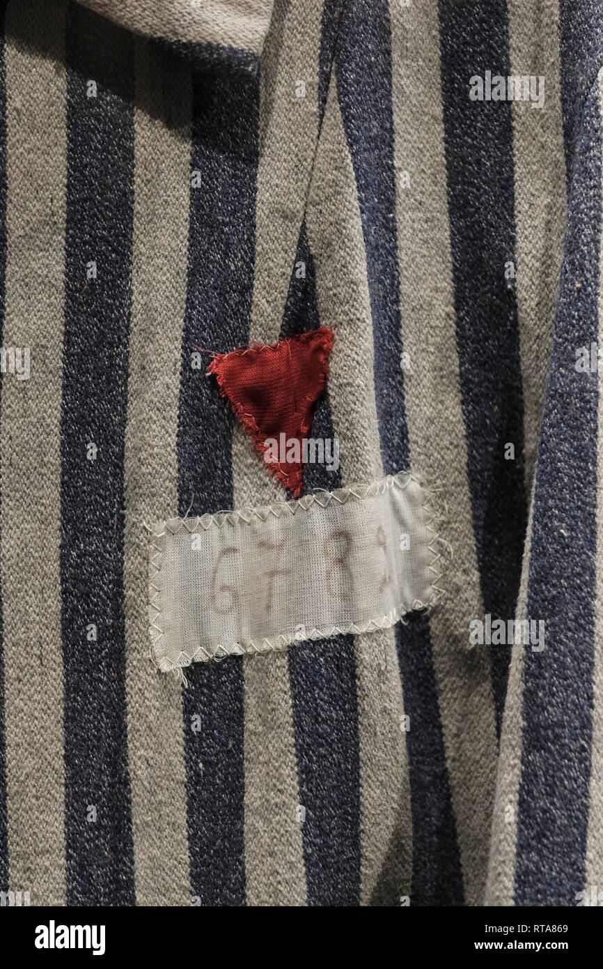 Red triangle badge to identify political prisoner stitched over a vertically striped prison uniform of Nazi concentration camp displayed inside the Belarusian Great Patriotic War Museum in the city of Minsk, capital of Belarus Stock Photo