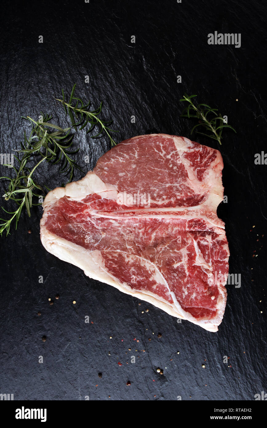 Raw Tbone steak on stone plate. bbq bone steak set Stock Photo Alamy