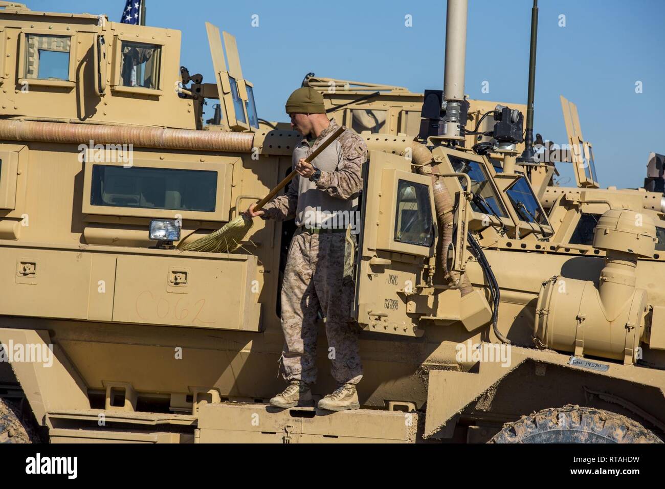 U.S. Marine Corps 1st Lt Alexander Van Dyke, a platoon commander with 3rd Battalion, 4th Marine Regiment, attached to Special Purpose Marine Air-Ground Task Force Crisis Response-Central Command, cleans the outside of a mine resistant, ambush protected vehicle in southwest Asia, Feb. 04, 2019. SPMAGTF-CR-CC is a quick reaction force, working by, with and through partner forces to defeat ISIS. Stock Photo