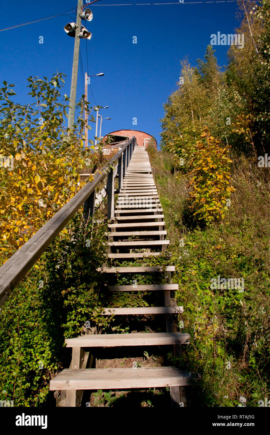 Long wood stairs up to top of bush-covered hill. Stock Photo