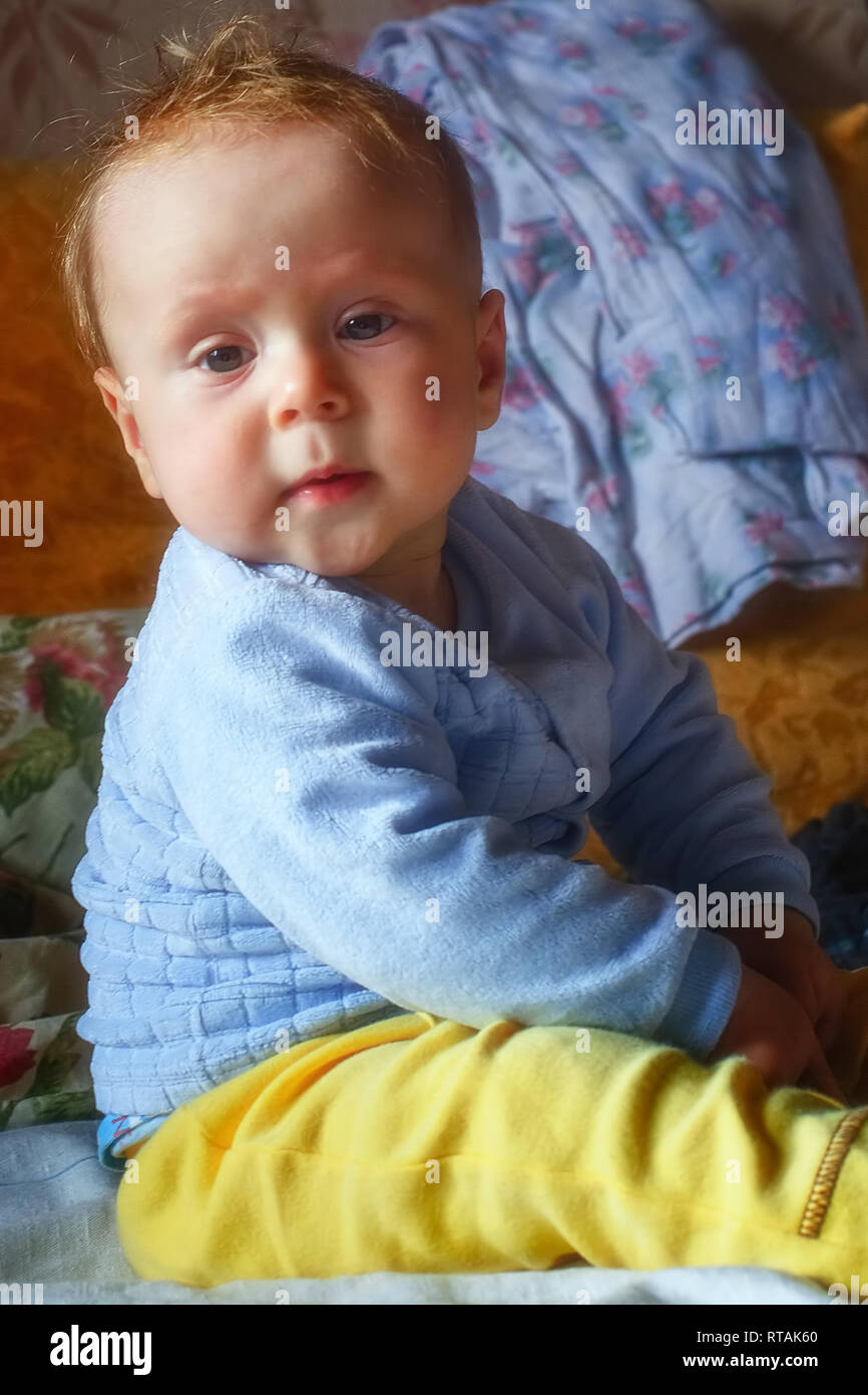 Beautiful baby boy at home sitting on the couch Stock Photo Alamy