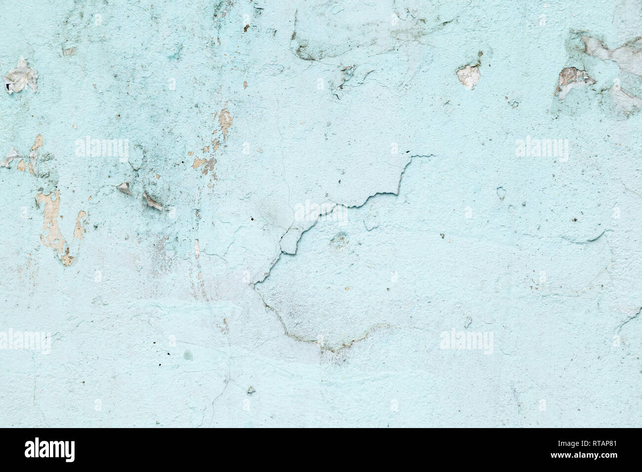 Textured background. Cracked concrete old wall. Light blue paint flakes on old rough concrete surface. Stock Photo