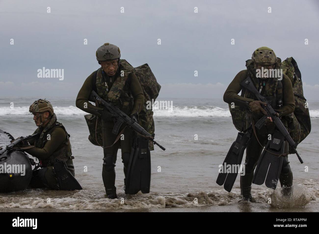 Japan Ground Self-Defense Force (JGSDF) Soldiers carry gear to shore after performing a surf passage in combat rubber raiding crafts during Iron Fist 2019, Feb. 1, on U.S. Marine Corps Base Camp Pendleton, CA. Exercise Iron Fist is an annual, multilateral training exercise where U.S. and Japanese service members train together and share techniques, tactics and procedures to improve their combined operational capabilities. Stock Photo