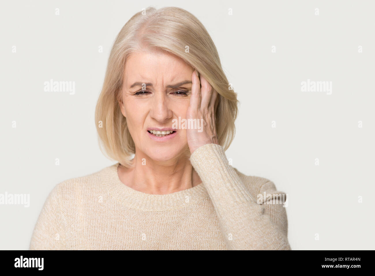 Stressed upset middle aged woman suffering from terrible headache concept Stock Photo