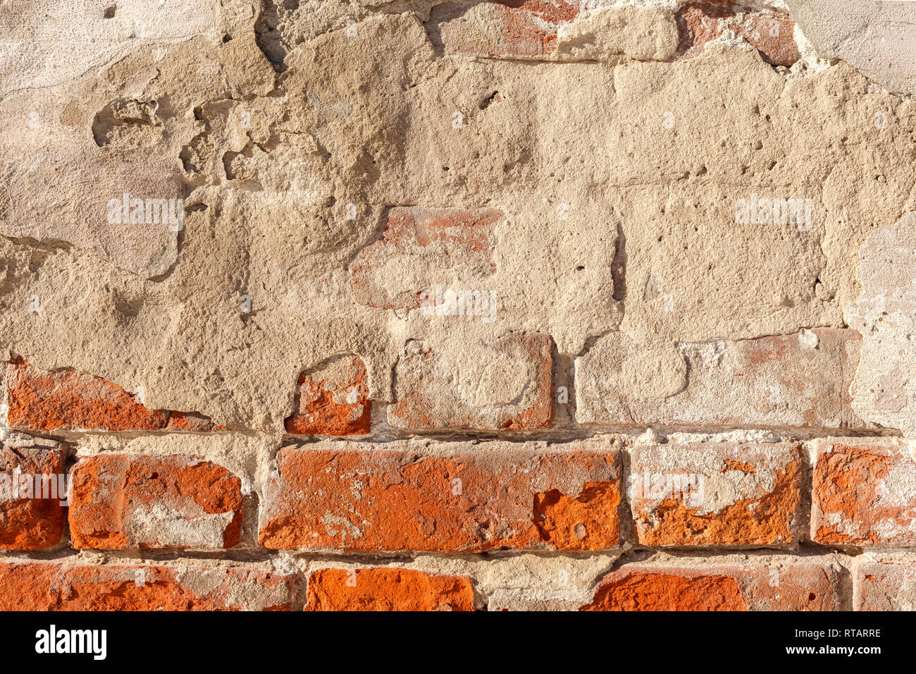 Stucco on a brick wall. Plaster falling off of an old brick wall. Old