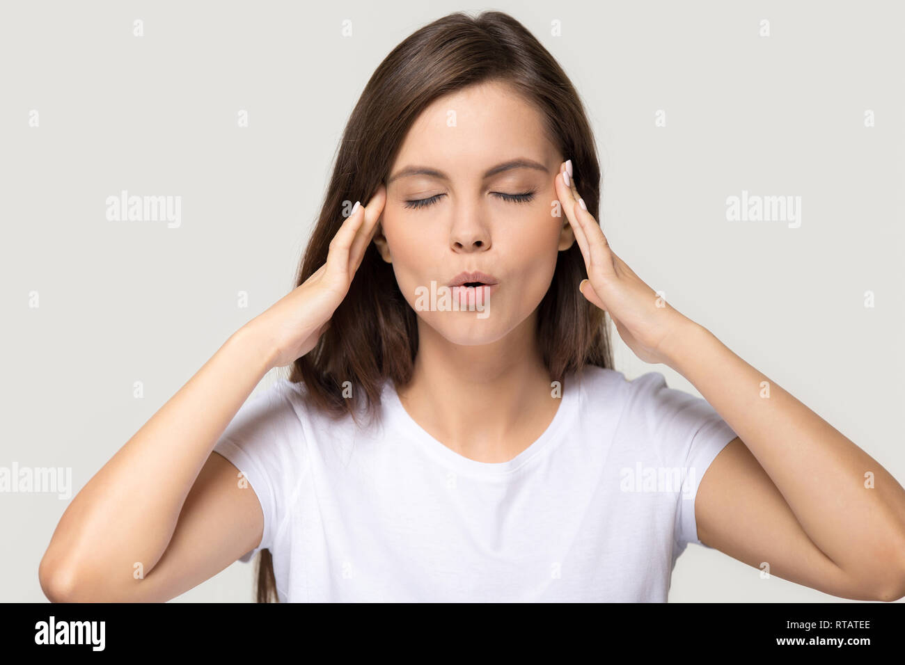 Stressed teen girl calming down massaging temples isolated on background Stock Photo