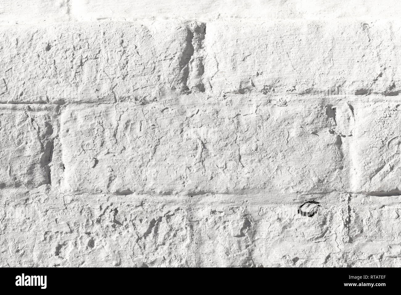 White painted old brick wall texture. Bleached rough aged brickwork