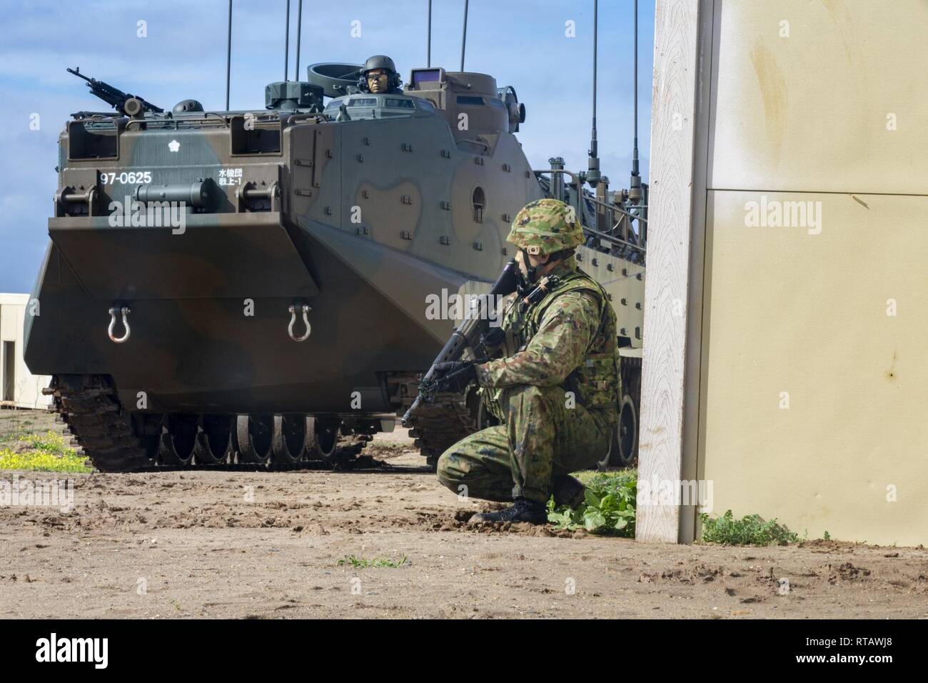 A Japan Ground Self-Defense Force (JGSDF) Soldier with 1st Amphibious Rapid Deployment Regiment, patrols alongside an assault amphibious vehicle through urban terrain during an amphibious landing exercise for Iron Fist 2019, Feb. 4, on U.S. Marine Corps Base Camp Pendleton, CA. Exercise Iron Fist is an annual, multilateral training exercise where U.S. and Japanese service members train together and share techniques, tactics and procedures to improve their combined operational capabilities. Stock Photo