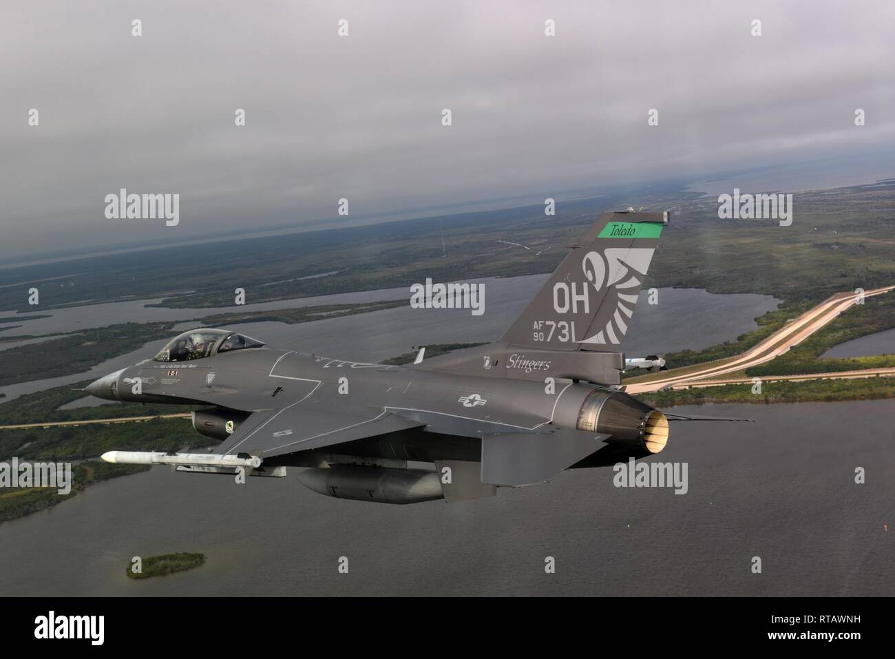 An F-16 Fighting Falcon flies over the coast of Florida during a training sortie during a deployment at Patrick Air Force Base, Feb. 4, 2019. As part of the Patrick AFB deployment, the 180FW will conduct Dissimilar Air Combat Training, Basic Fighter Maneuvers, Defensive Air Counter Tactics and Tactical Intercept missions alongside F-15 Eagles assigned to the 104th Fighter Wing, Barnes Air National Guard Base, Massachusetts. Stock Photo