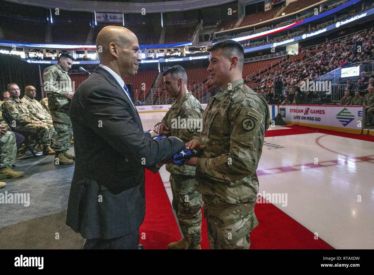 U.S. Sen. Cory Booker, left, present an American flag to Capt. John F ...