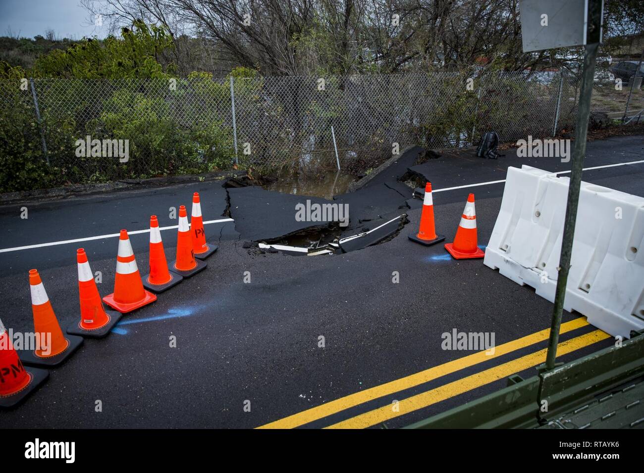 A Sinkhole Is Blocked Off By Road Barriers On Carnes Road At