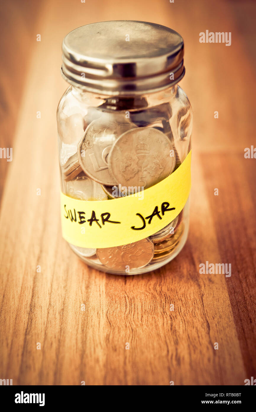 swear jar with coins inside Stock Photo