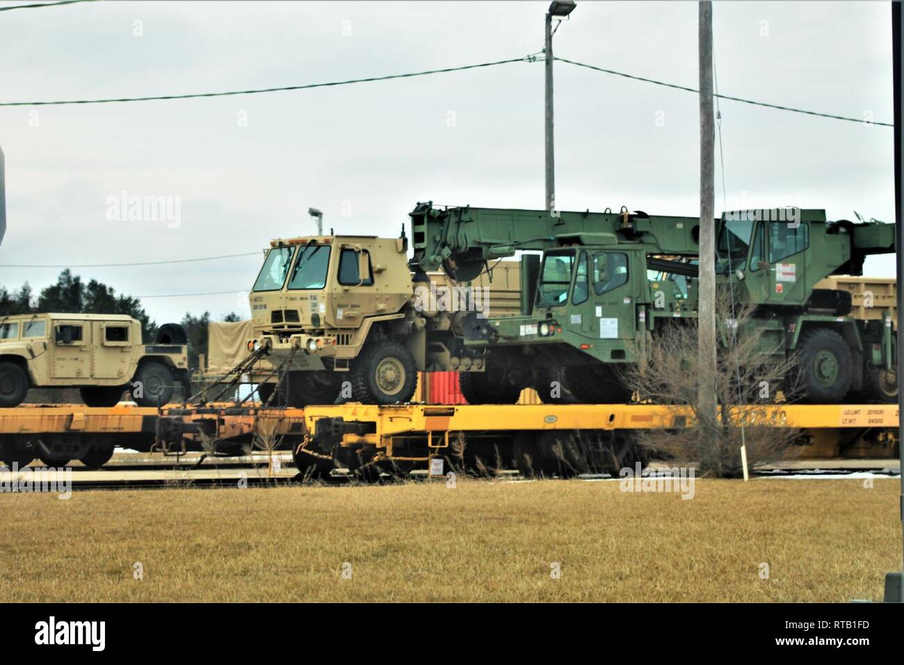 Military vehicles and equipment with the 389th Engineer Battalion is loaded on railcars Feb. 5, 2019, at the rail yard at Fort McCoy, Wis. The movement is for the 389th’s future involvement in Operation Resolute Castle 2019 in Poland. Unit Soldiers loaded 38 cars with vehicles and equipment after receiving training in a rail head operations class by representatives of Marine Corps Logistics Base-Barstow, Calif. Fort McCoy’s Logistics Readiness Center personnel assisted with the loading operations. Stock Photo