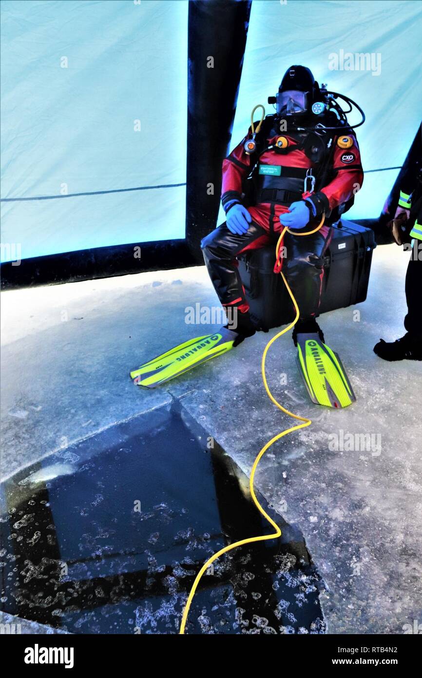 A firefighter wearing a full diving suit and related equipment prepares to  dive under the ice Feb. 6, 2019, at Big Sandy Lake on South Post at Fort  McCoy, Wis. About a