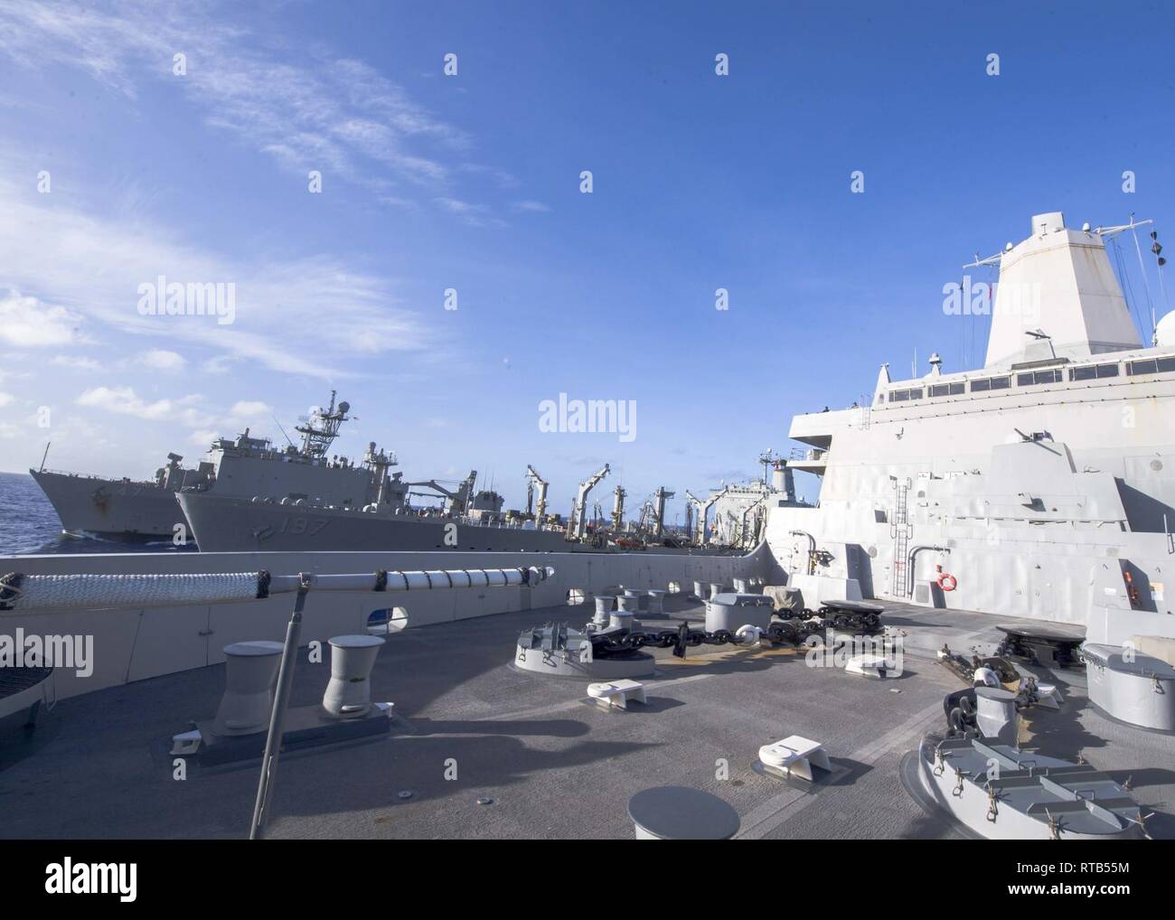 PACIFIC OCEAN (Feb. 7, 2019) The San Antonio-class amphibious transport dock ship USS Anchorage (LPD 23), right, participates in an underway replenishment with fleet replenishment oiler USNS Pecos (T-AO 197), center, and the Whidbey Island-class amphibious dock landing ship USS Rushmore (LSD 47) during a deployment of the Essex Amphibious Ready Group (ARG) and 13th Marine Expeditionary Unit (MEU). The Essex ARG/13th MEU is a capable and lethal Navy-Marine Corps team deployed to the 7th fleet area of operations to support regional stability, reassure partners and allies and maintain a presence  Stock Photo