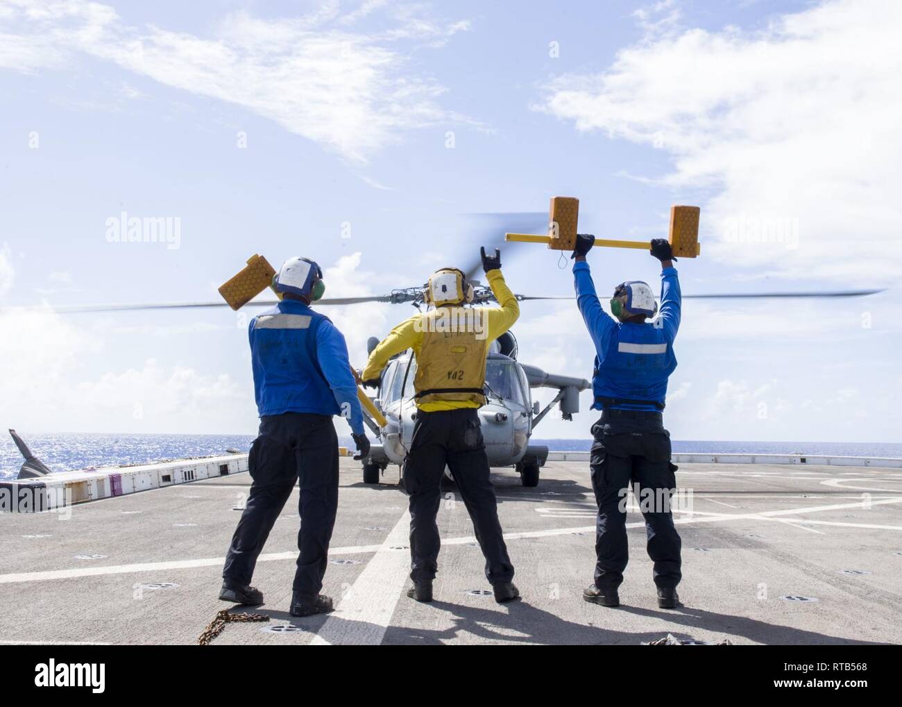 PACIFIC OCEAN (Feb. 7, 2019) Sailors assigned to the San Antonio-class amphibious transport dock ship USS Anchorage (LPD 23) display chocks to the pilots of a MH-60S Sea Hawk helicopter, attached to the “Blackjacks” of Helicopter Sea Combat Squadron (HSC) 21, during flight operations. Anchorage is on a deployment of the Essex Amphibious Ready Group (ARG) and 13th Marine Expeditionary Unit (MEU). The Essex ARG/13th MEU is a capable and lethal Navy-Marine Corps team deployed to the 7th fleet area of operations to support regional stability, reassure partners and allies and maintain a presence po Stock Photo