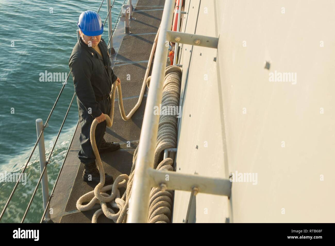 ARABIAN GULF (Feb. 7, 2019) Machinist Mate 2nd Class Oscar Rodriguez secures line aboard the Cyclone-class coastal patrol ship USS Thunderbolt (PC 12). Thunderbolt is forward deployed to the U.S. 5th Fleet area of operations in support of naval operations to ensure maritime stability and security in the Central region, connecting the Mediterranean and the Pacific through the western Indian Ocean and three strategic choke points. Stock Photo