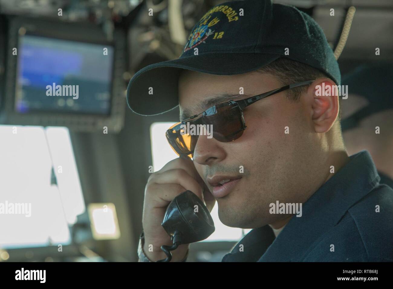 ARABIAN GULF (Feb. 7,2019) Lt. j.g. Enrique Montygierd, operations officer, uses the 1MC shipboard announcing system aboard the Cyclone-class coastal patrol ship USS Thunderbolt (PC 12). Thunderbolt is forward deployed to the U.S. 5th Fleet area of operations in support of naval operations to ensure maritime stability and security in the Central region, connecting the Mediterranean and the Pacific through the western Indian Ocean and three strategic choke points. Stock Photo
