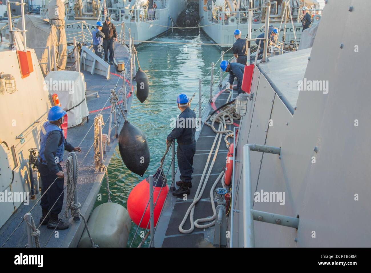 MANAMA, Bahrain (Feb. 7, 2019) Sailors retrieve line in preparation for departure aboard the Cyclone-class coastal patrol ship USS Thunderbolt (PC 12). Thunderbolt is forward deployed to the U.S. 5th Fleet area of operations in support of naval operations to ensure maritime stability and security in the Central region, connecting the Mediterranean and the Pacific through the western Indian Ocean and three strategic choke points. Stock Photo