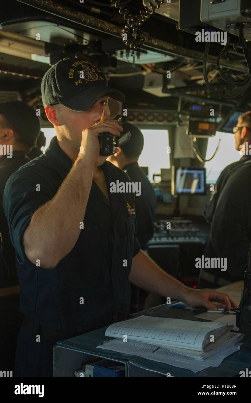 ARABIAN GULF (Feb. 7, 2019) Operations Specialist Seaman Joseph Parrella uses a radio aboard the Cyclone-class coastal patrol ship USS Thunderbolt (PC 12). Thunderbolt is forward deployed to the U.S. 5th Fleet area of operations in support of naval operations to ensure maritime stability and security in the Central region, connecting the Mediterranean and the Pacific through the western Indian Ocean and three strategic choke points. Stock Photo