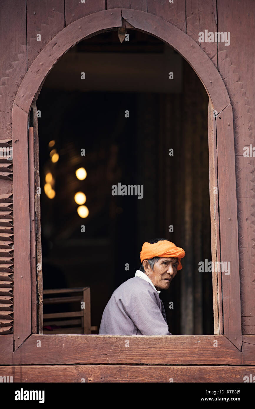 Portrait of a Burmese elder at a wooden window of the Shwe Yan Pyay Monastery in Nyaungshwe, Myanmar (Burma). Stock Photo