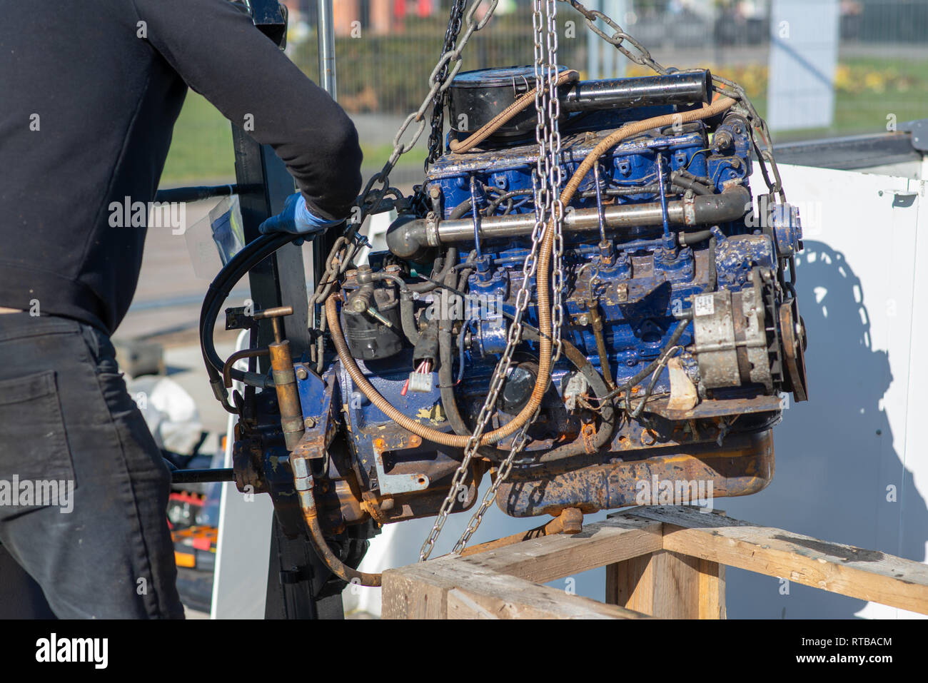 mechanic uses lifting equipment to remove engine block from boat Stock