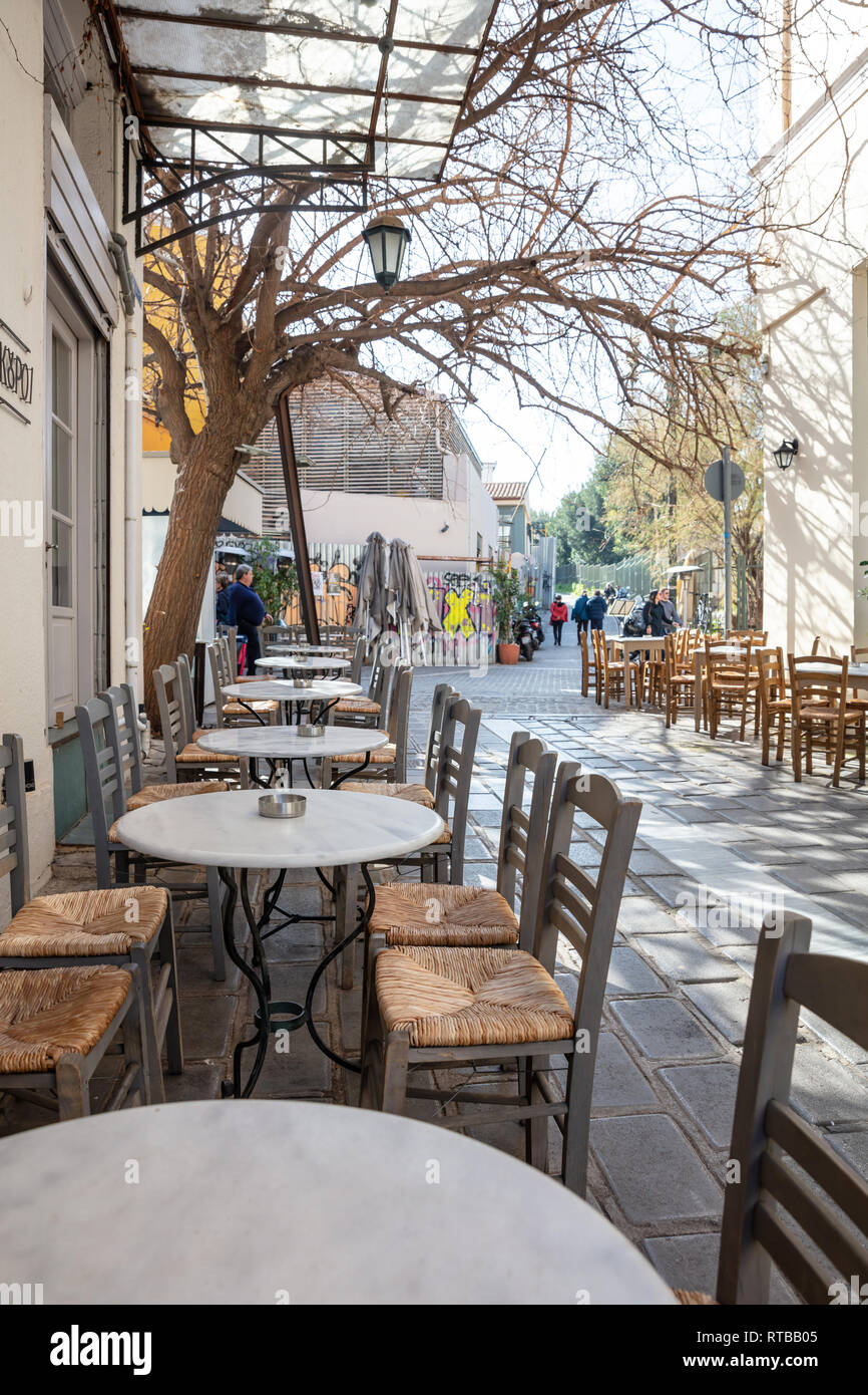 February 19, 2019. Athens Greece, Monastiraki, Plaka area, Empty outdoors cafe tables and chairs in row on paved street Stock Photo
