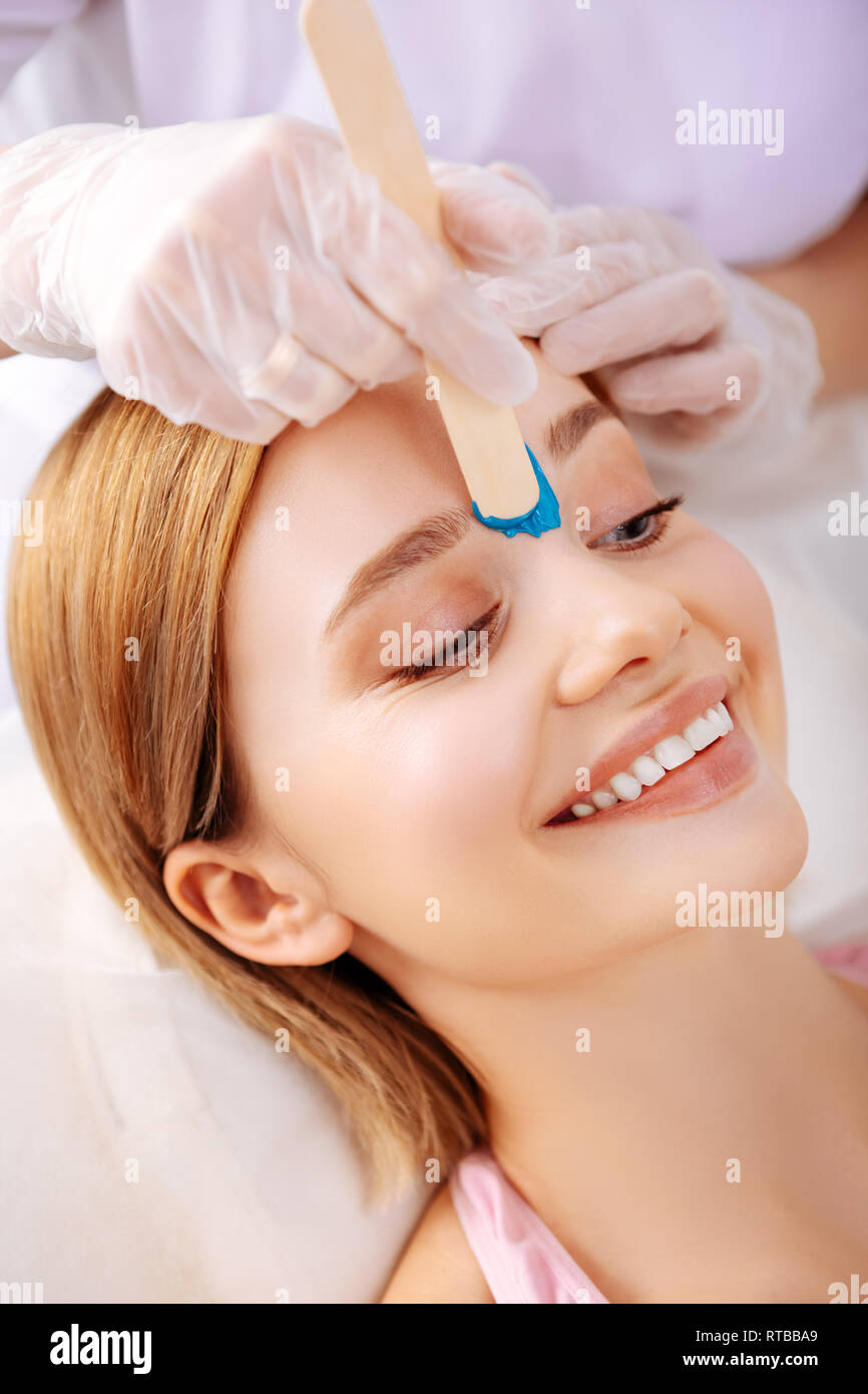 Young photo model smiling while waxing line between eyebrows Stock Photo Alamy