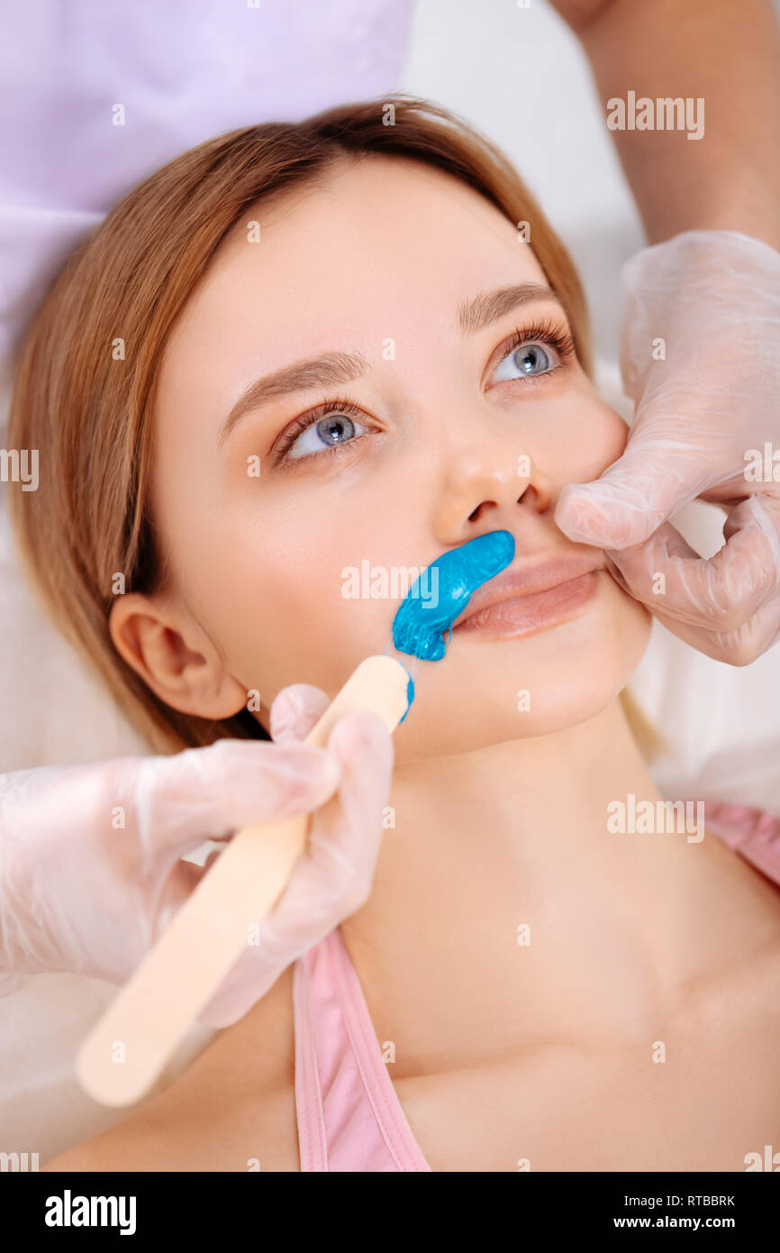 Depilatory Master Removing Unwanted Hair Under Nose Of Client