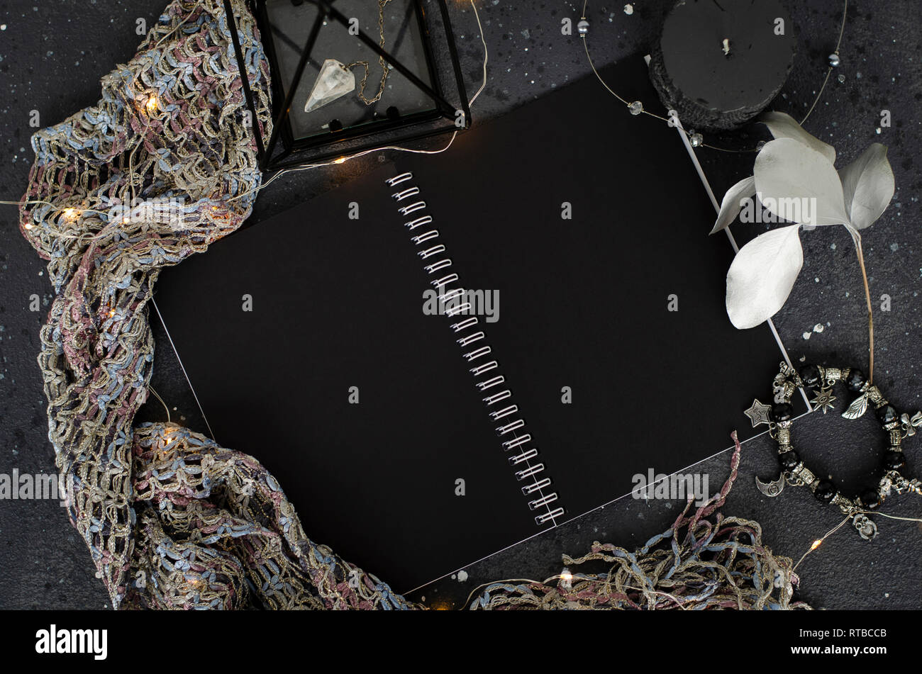 Opened notebook with black sheets on dark background. Top view. Stock Photo