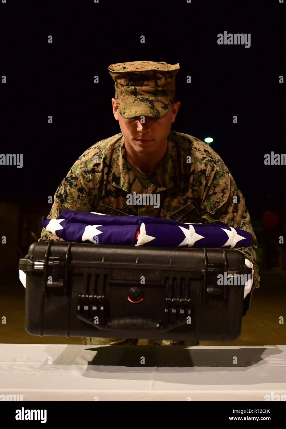 U.S. Marine Corps Sgt. Austin Blocker, a member of the Defense POW/MIA Accounting Agency (DPAA), carries a case containing possible remains of unidentified service members during an honorable carry at Joint Base Pearl Harbor-Hickam, Hawaii, Feb. 3, 2019. The remains, recently repatriated from Papua New Guinea, will be examined by forensic anthropolists and odontologists at DPAA's skeletal laboratory, where the process of identification will begin. DPAA's mission is to provide the fullest possile accounting for our missing personnel to their families and the nation Stock Photo