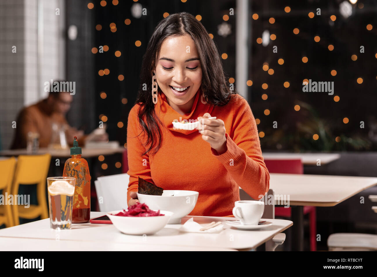 Pleasant long-haired woman tasting soup with pleasure. Stock Photo