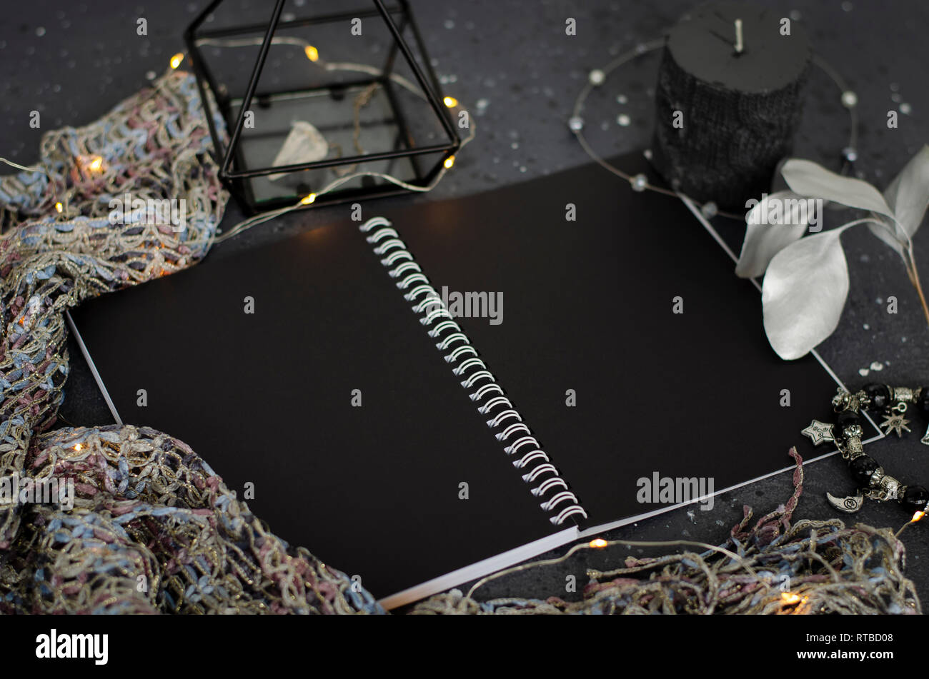 Opened notebook with black sheets on dark background. Top view. Stock Photo