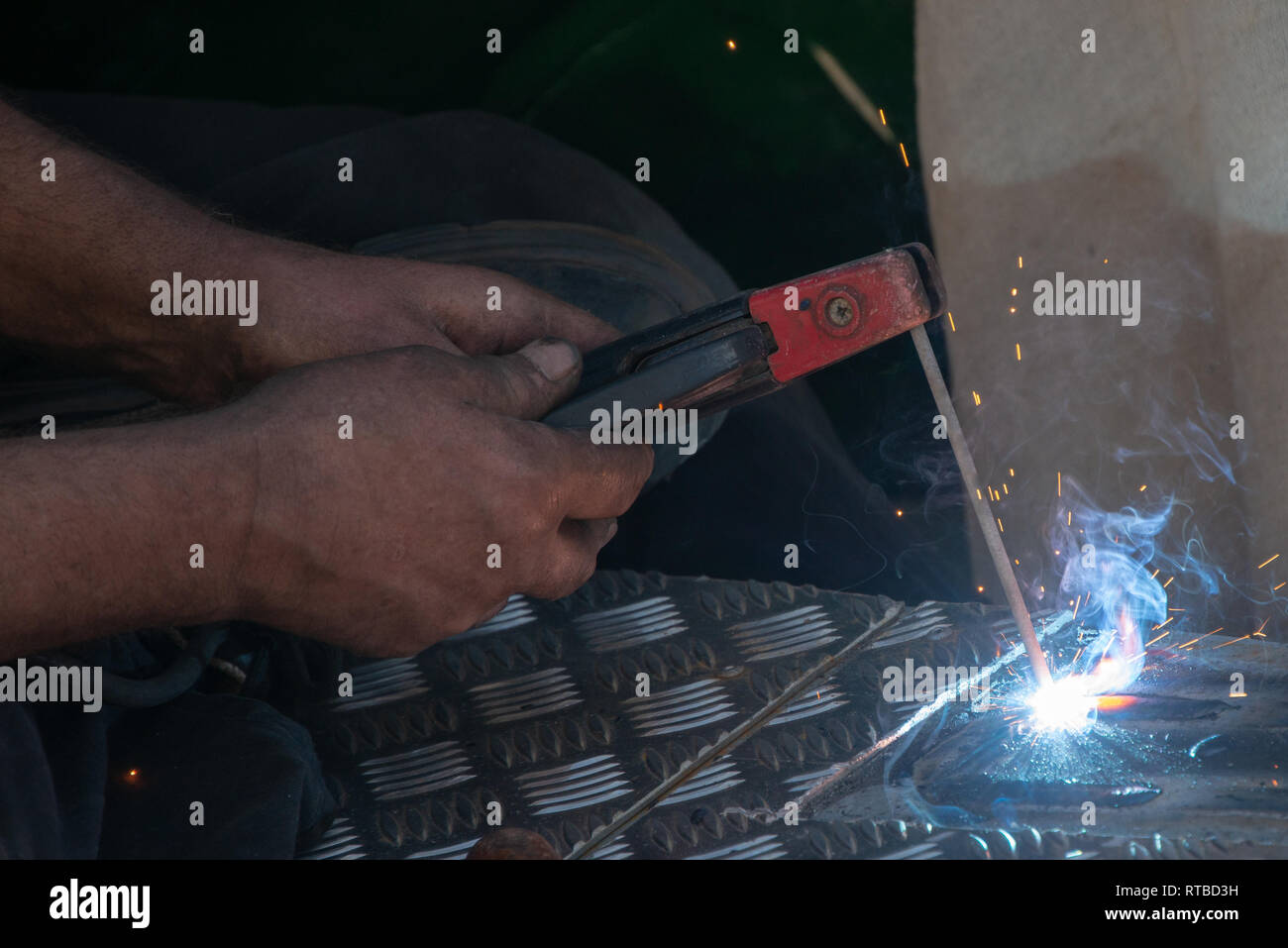 man using electric arc welder Stock Photo